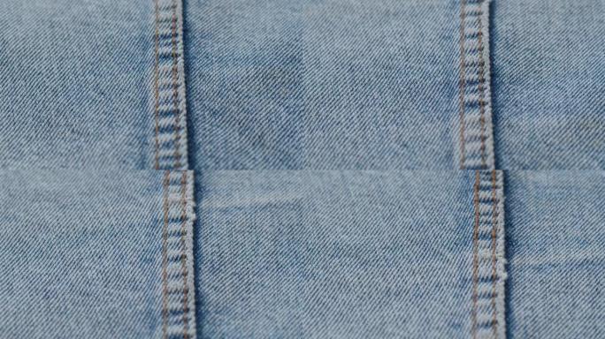 蓝色牛仔裤面料特写。牛仔布纹理，抽象背景。裁缝工业和服装概念，手工缝制。纺织材料