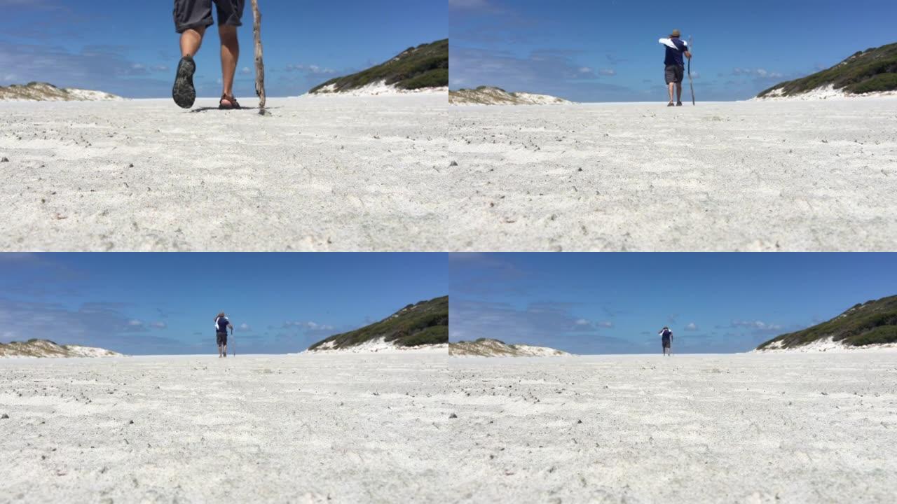 澳大利亚男子在西澳大利亚州的白色沙丘上徒步旅行。
