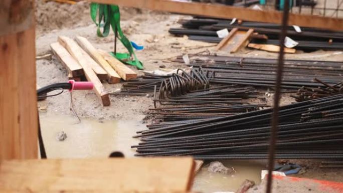 用于钢筋混凝土的钢铁钢筋棒存放在建筑工地的户外，在雨天生锈