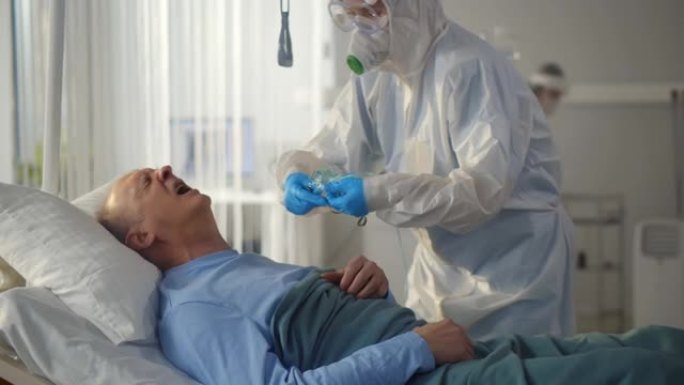 护士给躺在医院病床的老人戴上氧气面罩