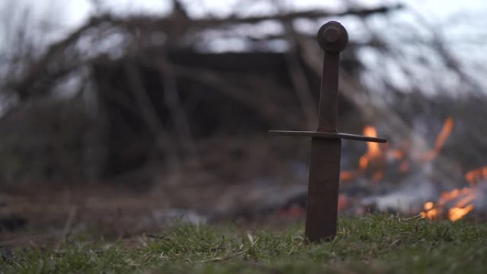 生锈的剑在火的背景下在地面上