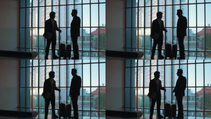 商人和女商人的剪影在一个有巨大窗户的大办公室里与每个人交谈