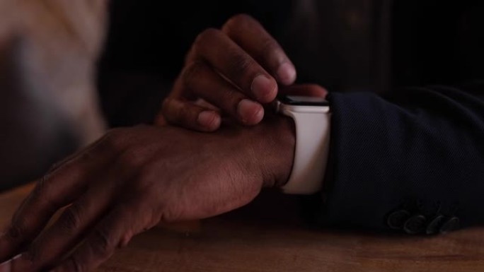 特写镜头非洲商人在咖啡馆里触摸智能手表