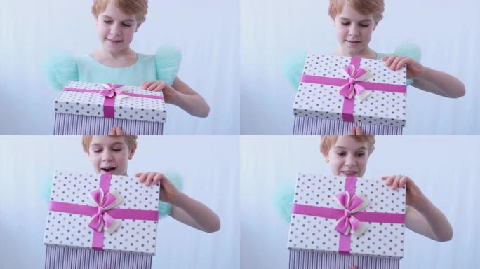 一个穿着漂亮晚礼服的少女。孩子用礼物打开盒子。从盒子里的惊喜中获得惊喜和幸福的情感