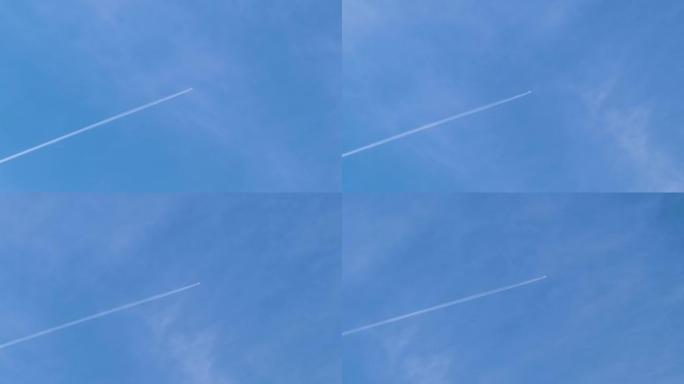 遥远的客机在蓝天上高空飞行，白云在后面留下了轨迹的烟雾痕迹。航空旅行概念