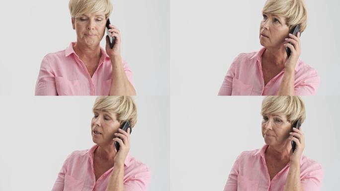 严肃的金发老妇人用智能手机接电话，与某人意见分歧