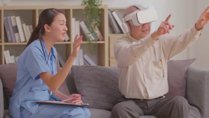 亚洲女医生建议老年患者使用VR或虚拟现实眼镜耳机指向物体或触摸跟踪健康