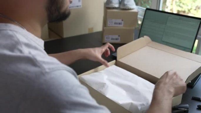 男性网上商店的特写视图小企业主卖方企业家包装包装后装运箱准备送货包裹在桌子上。电子商务送货服务概念。