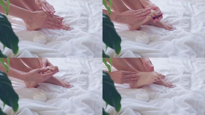 女人的手用奶油润滑脚。护肤概念。自爱