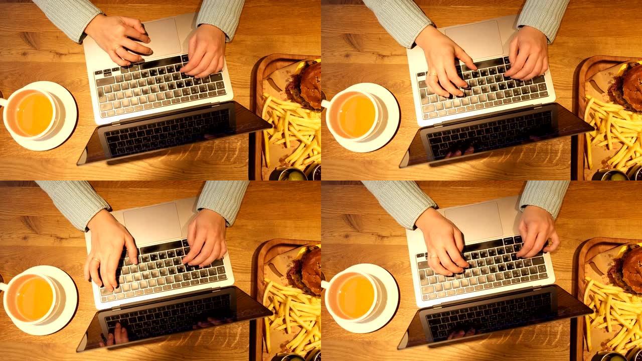 坐在咖啡馆的俯视图女人在笔记本电脑键盘上打字