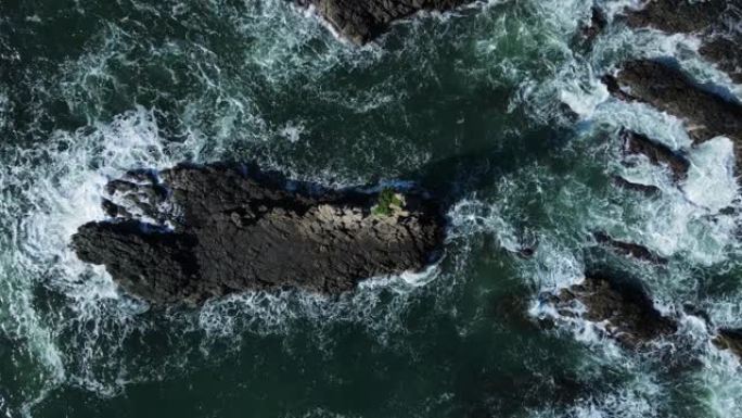 海浪冲破沿海岬角上高耸的火山岩壁架。无人机视图