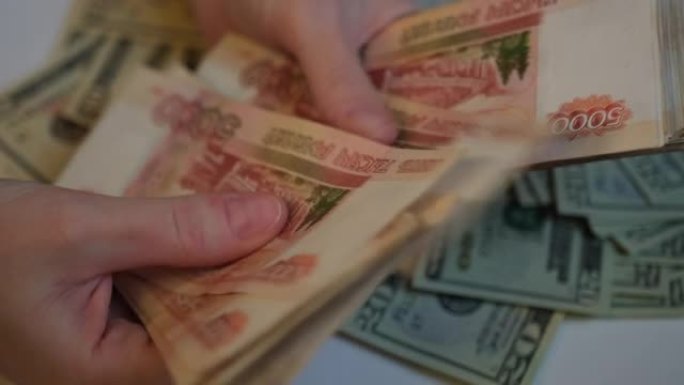 妇女的手拿着5,000卢布的俄罗斯钞票，用手指用扇子数。