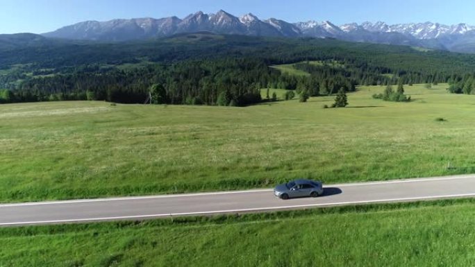 在空旷的道路上行驶的山路和豪华轿车的鸟瞰图。在大塔特拉山脉的背景下。概念: 山区度假，家庭公路旅行，