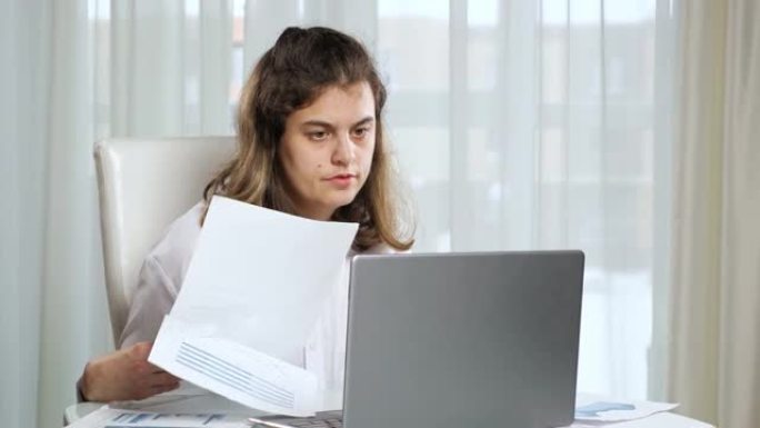 残疾女性自由职业者在家里的桌子上用笔记本电脑工作