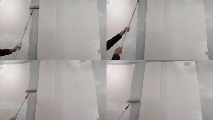 大师用滚筒刷将墙壁涂成灰色