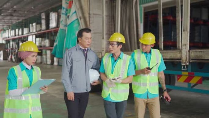 亚洲工厂经理与他的团队一起在仓库中处理清单和仓库中的装运订单
