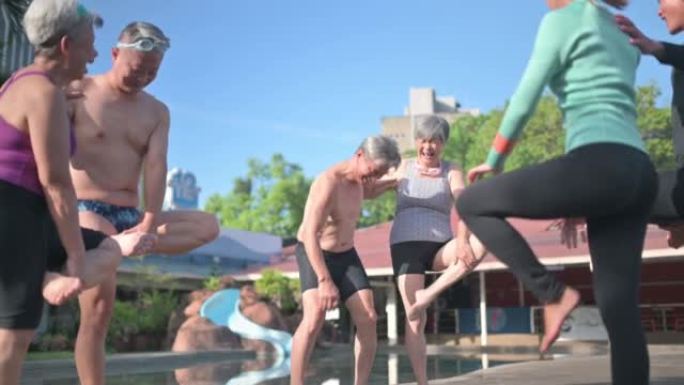 亚洲中国高级女子在热身运动中失去平衡，在池畔游泳课前单腿站立，向游泳教练学习