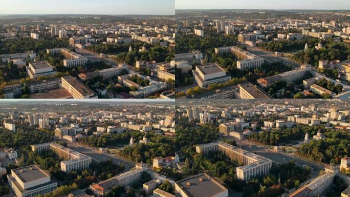 日落时基希讷乌的空中无人机视图。多个建筑物，道路和桥梁与汽车。有绿色植物的公园