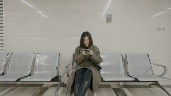 迷路的年轻女子坐在医院里看着手机