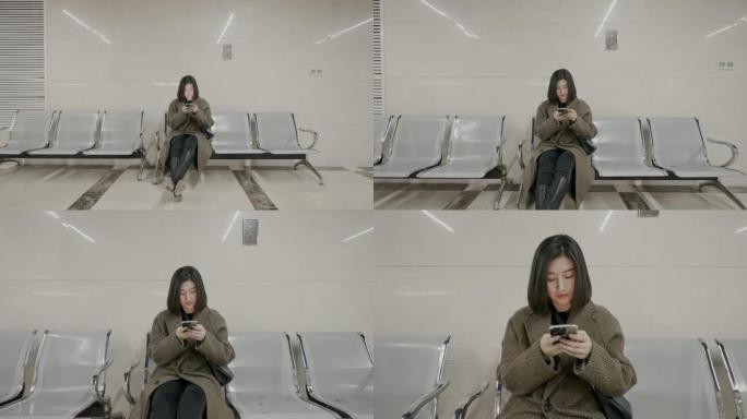 迷路的年轻女子坐在医院里看着手机