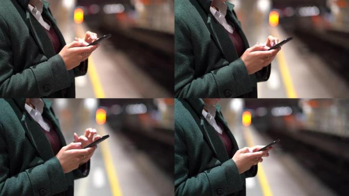 忙碌的女人在地铁站平台上使用手机，用于社交媒体或商业电子邮件