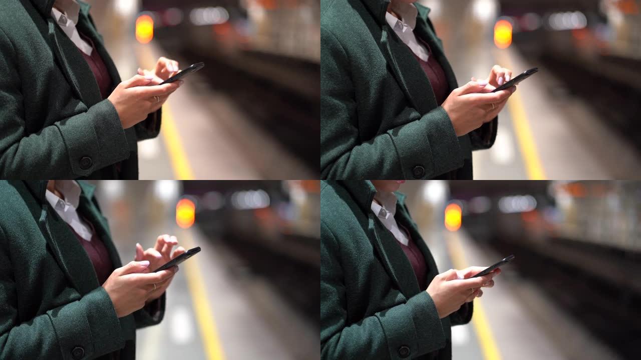忙碌的女人在地铁站平台上使用手机，用于社交媒体或商业电子邮件