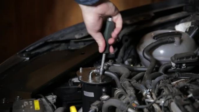 汽车机械师在更换汽车滤清器后扭转其烧瓶。汽车燃油系统维修，工业