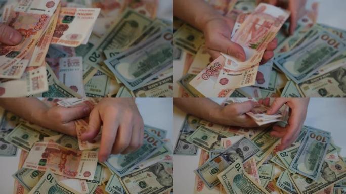 一堆钱俄罗斯卢布和美元，男性手选择5000张俄罗斯钞票，并把它们放在一个包里。