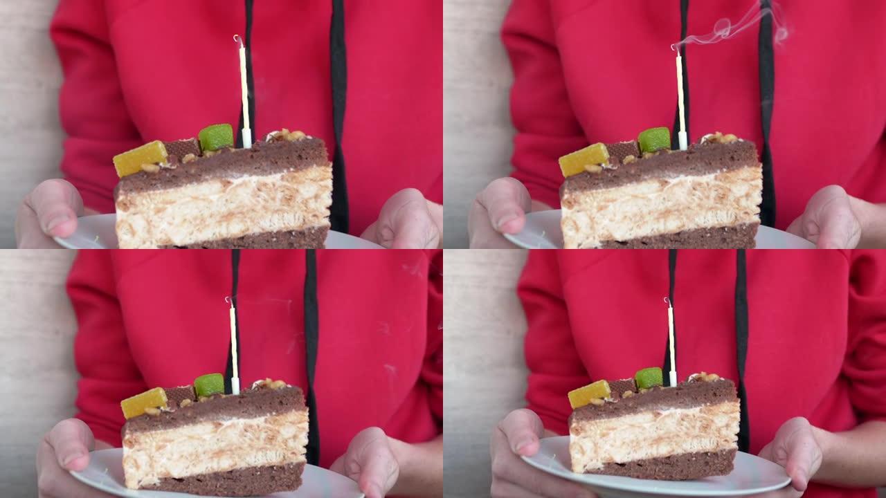 一个少年在一块生日巧克力蛋糕上吹出一支蜡烛。缩放