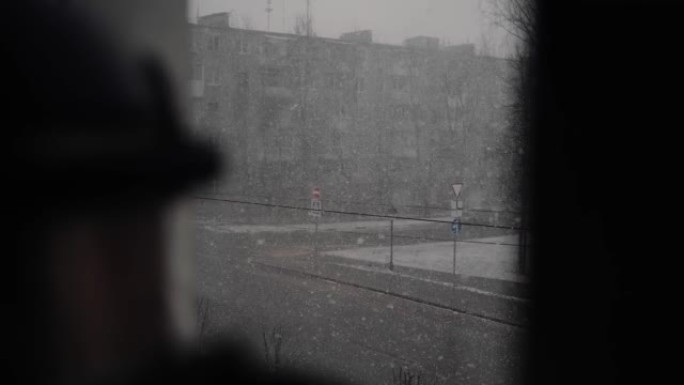 窗外降下大雪，一辆汽车正在沿路行驶。恶劣天气。一堵雪墙