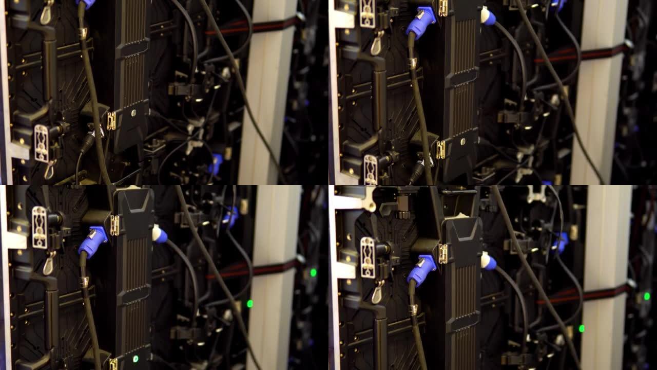 大屏幕显示器显示发光二极管面板，背面后视图，带黑色蓝色电缆连接器，带许多广告背景的小部分