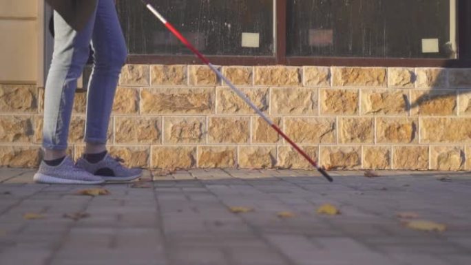 16、视障女子拄着拐杖走在街上，为视障人士慢莫行