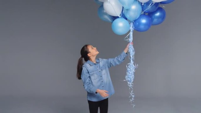 工作室用一堆蓝色气球射击女孩