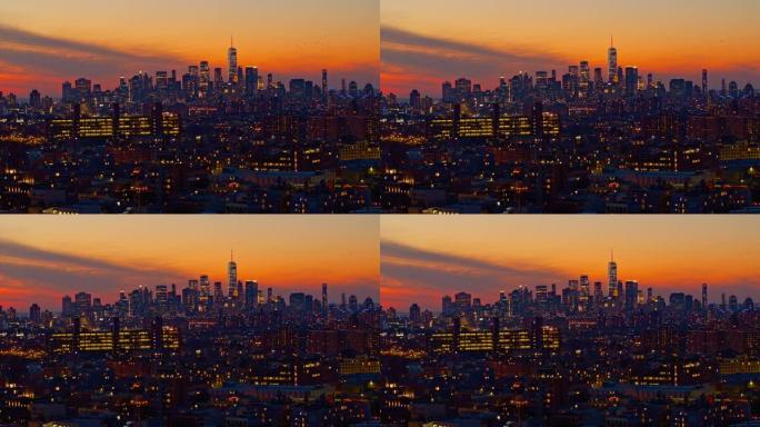 鸟儿在曼哈顿市中心戏剧性的天空中飞行，自由塔在夜晚照亮。日落时分，可以看到布鲁克林住宅区的远景。静态