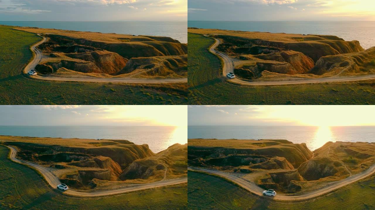 汽车在日落时在海边行驶。神话般的风景和自然。海边的沙质峡谷和阳光。旅游地点