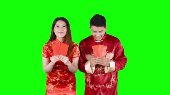 亚洲情侣在演播室捧着红包