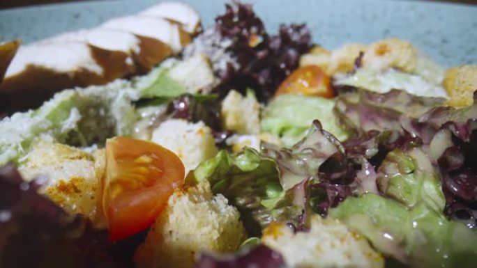 新鲜凯撒沙拉配鸭肉、番茄、生菜、油炸面包块和奶酪。蔬菜多汁的沙拉，肉和美味的酱汁放在灰色盘子上。健康