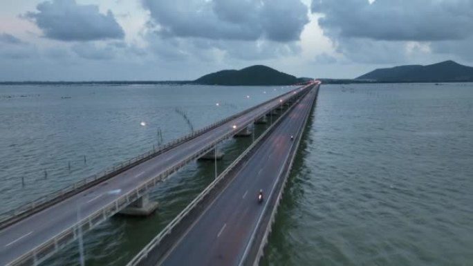 在泰国宋卡府，沿着横跨湖的桥梁行驶的汽车和车辆的空中无人机拍摄