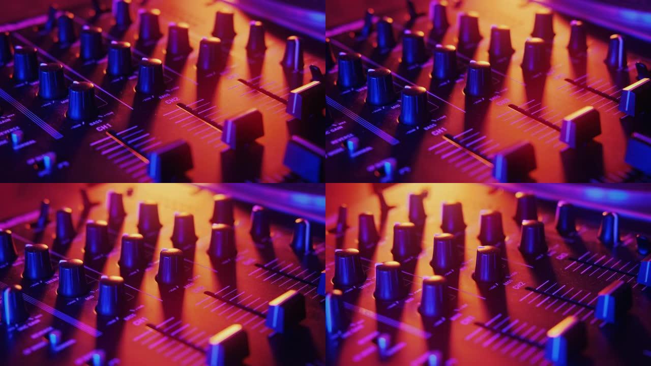 周围有霓虹红色和蓝色照明的音频混合控制台