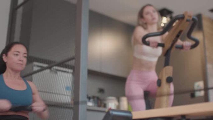 两个健康的女孩在现代健身中心的高档设备上锻炼 ..