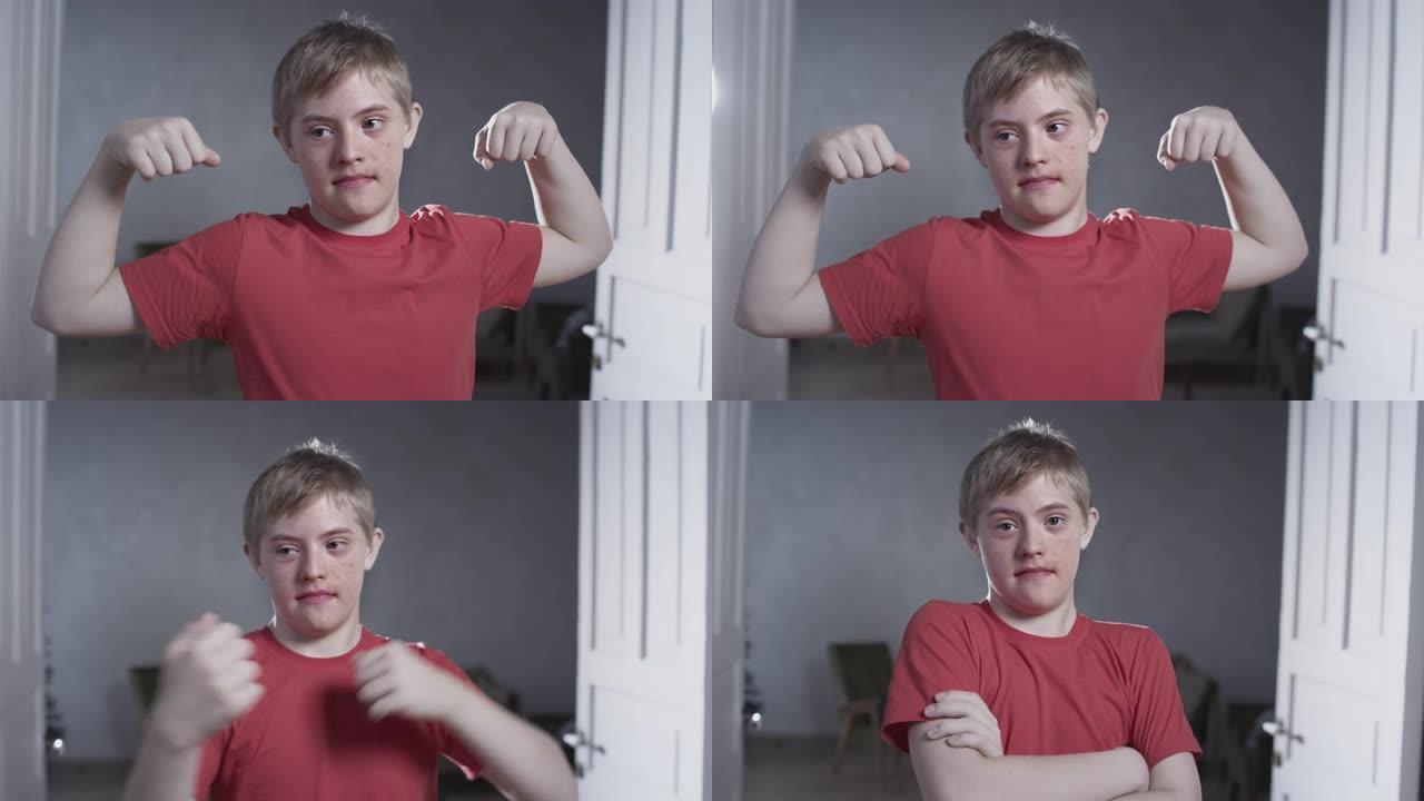 唐氏综合症男子的肖像。这孩子在家展示肌肉和二头肌。家庭锻炼和运动。有特殊需要的人