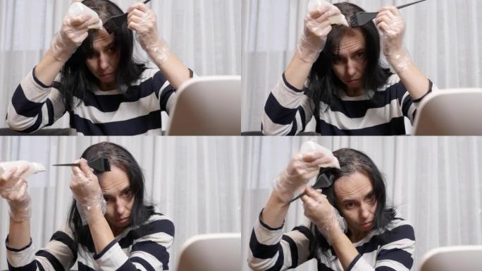 在家染发。中年妇女准备在家染发，看着深色头发重新长出的灰色根部