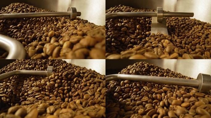 工厂工业咖啡焙烧机中的焙烧过程。混合烘焙咖啡豆。芳香棕豆旋转特写。咖啡馆的餐饮背景。慢动作