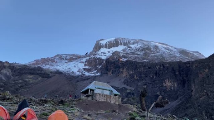 巴兰科营地。乞力马扎罗山、巴兰科墙和帐篷的壮丽景色。美丽的山景，游客和登山者。