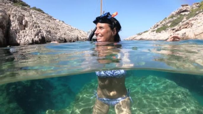 希腊扎金索斯的中年女性享受暑假和在海里游泳的4k视频