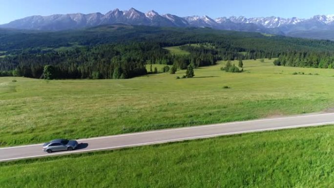 在空旷的道路上行驶的山路和豪华轿车的鸟瞰图。在大塔特拉山脉的背景下。概念: 山区度假，家庭公路旅行，