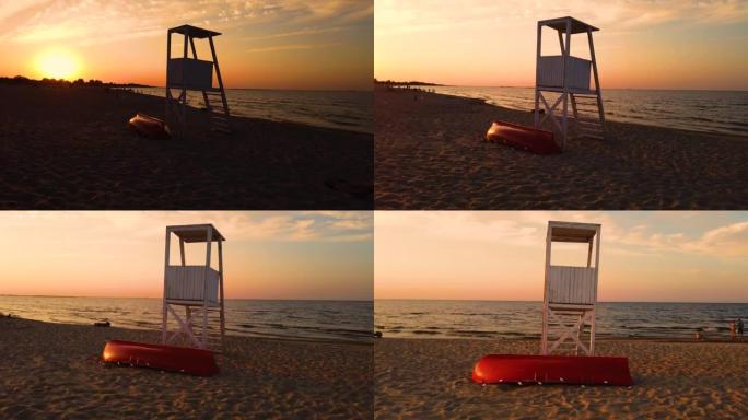 美丽的4k日落在海滩上，前景是救生员塔，背景是日落