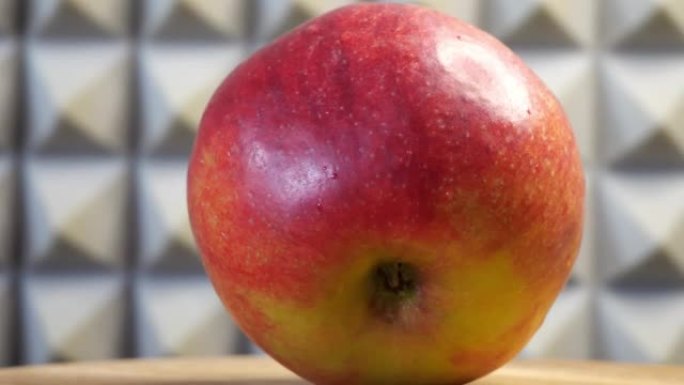 一个成熟的大苹果，特写。旋转木面上的红苹果。