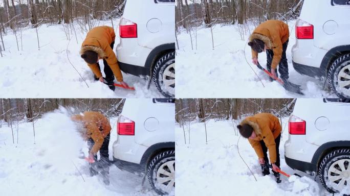 男子用汽车铲子在雪地里挖出失速的汽车。冬天的运输在降雪后被困在雪堆中，坐在底部。急救，拖车，冬季轮胎