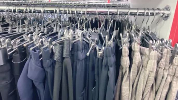 商店衣架上的灰色裤子，商店衣架上的衣服